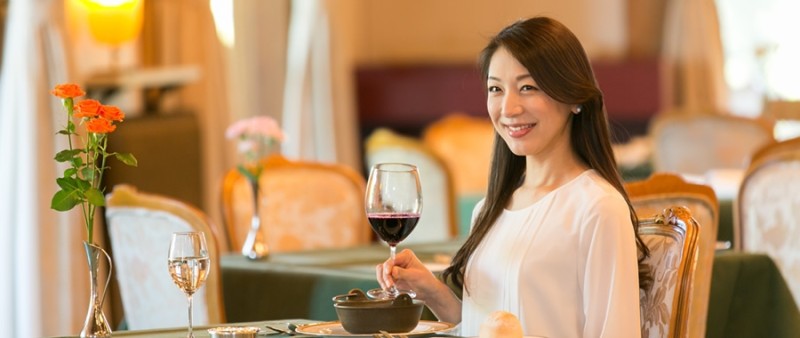 イメージ写真：レストラン三笠でグラスをかがける女性