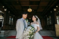 結婚式　正面玄関で見つめ合うタキシードとウェディングドレスの新郎新婦様